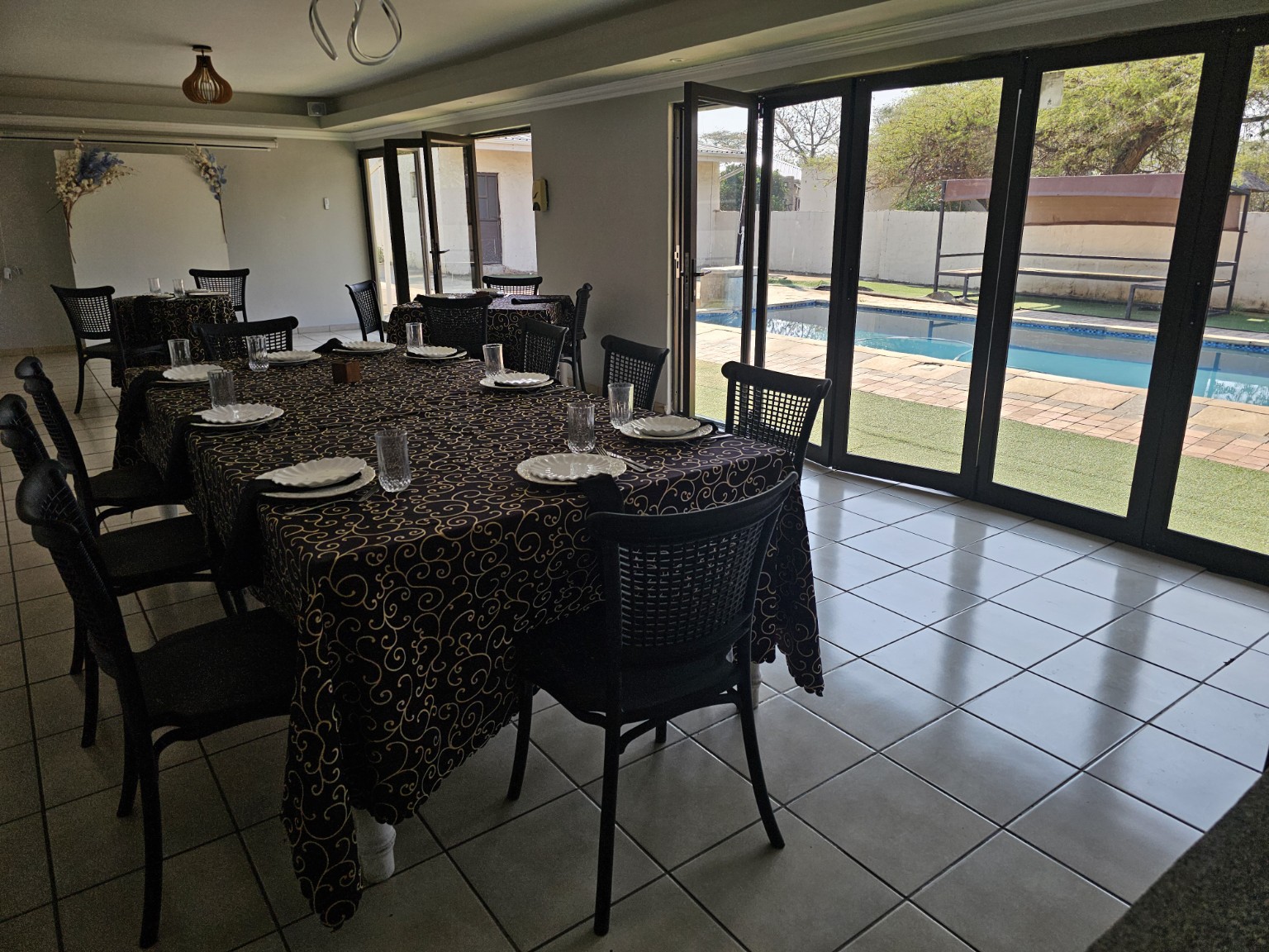 Pool house seating and dining area beside the swimming pool